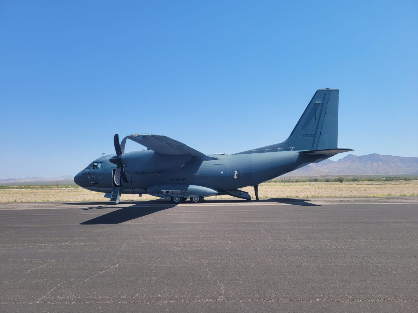 A blue airplane sitting on top of an airport runway.