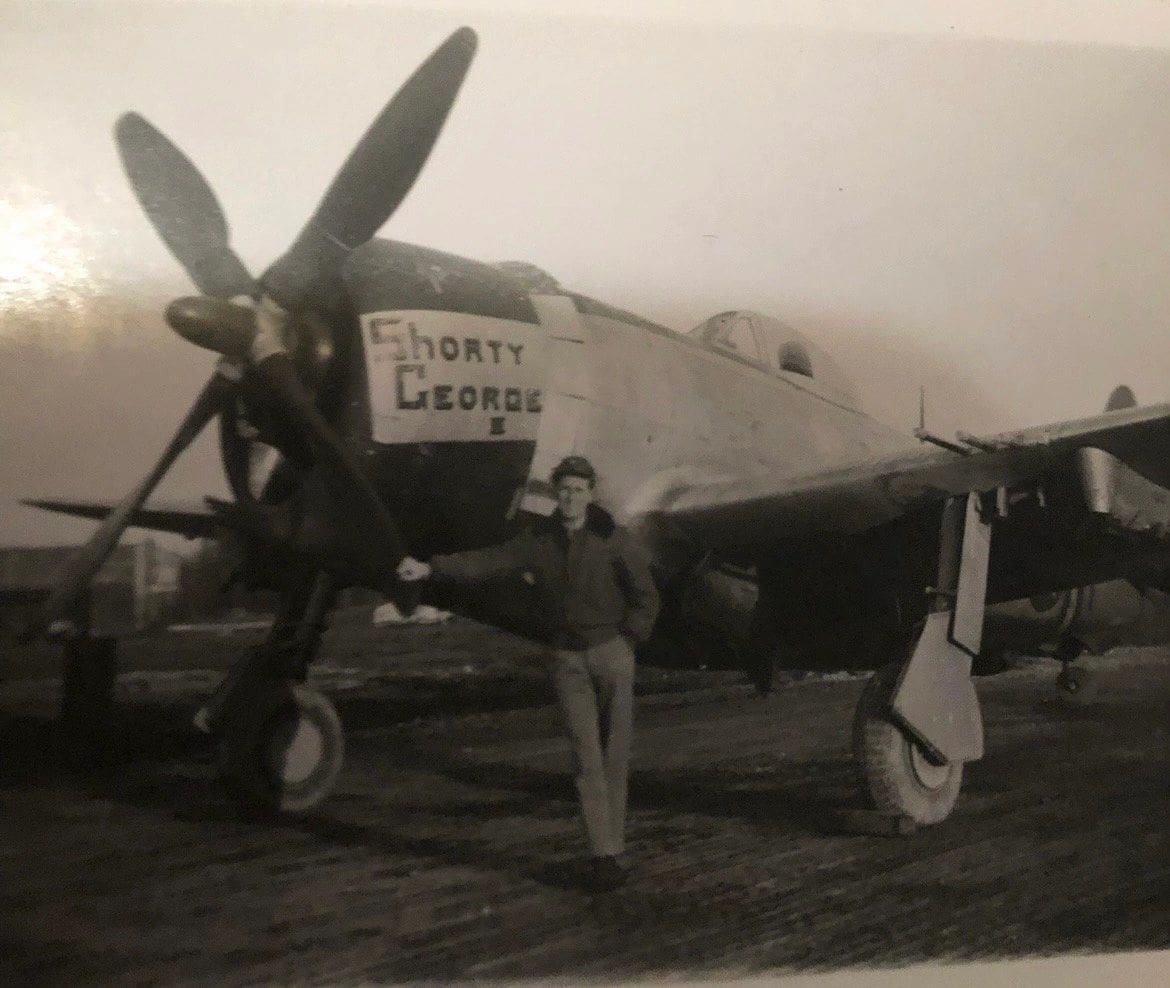 A man standing next to an old airplane.