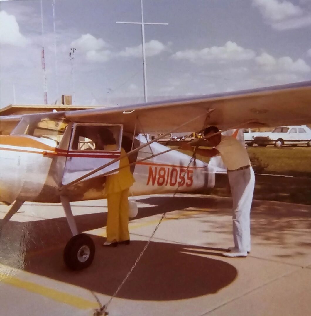 A man standing next to an airplane on the ground.