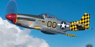 A fighter jet flying through the sky with clouds in background.