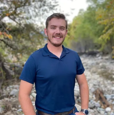 A man standing in front of some rocks