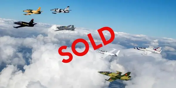 A group of planes flying in the sky with " sold " written on top.