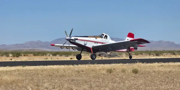 A small airplane is on the runway of an airport.