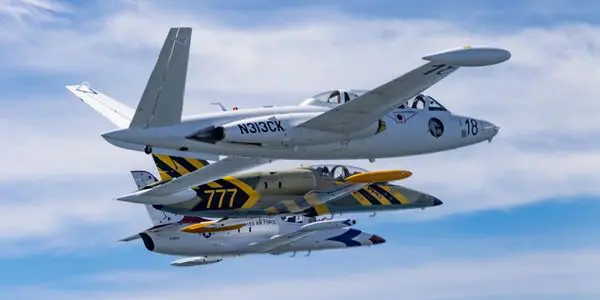 Two fighter jets flying in the air with a sky background