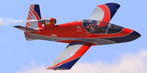 A red and blue plane flying in the sky.