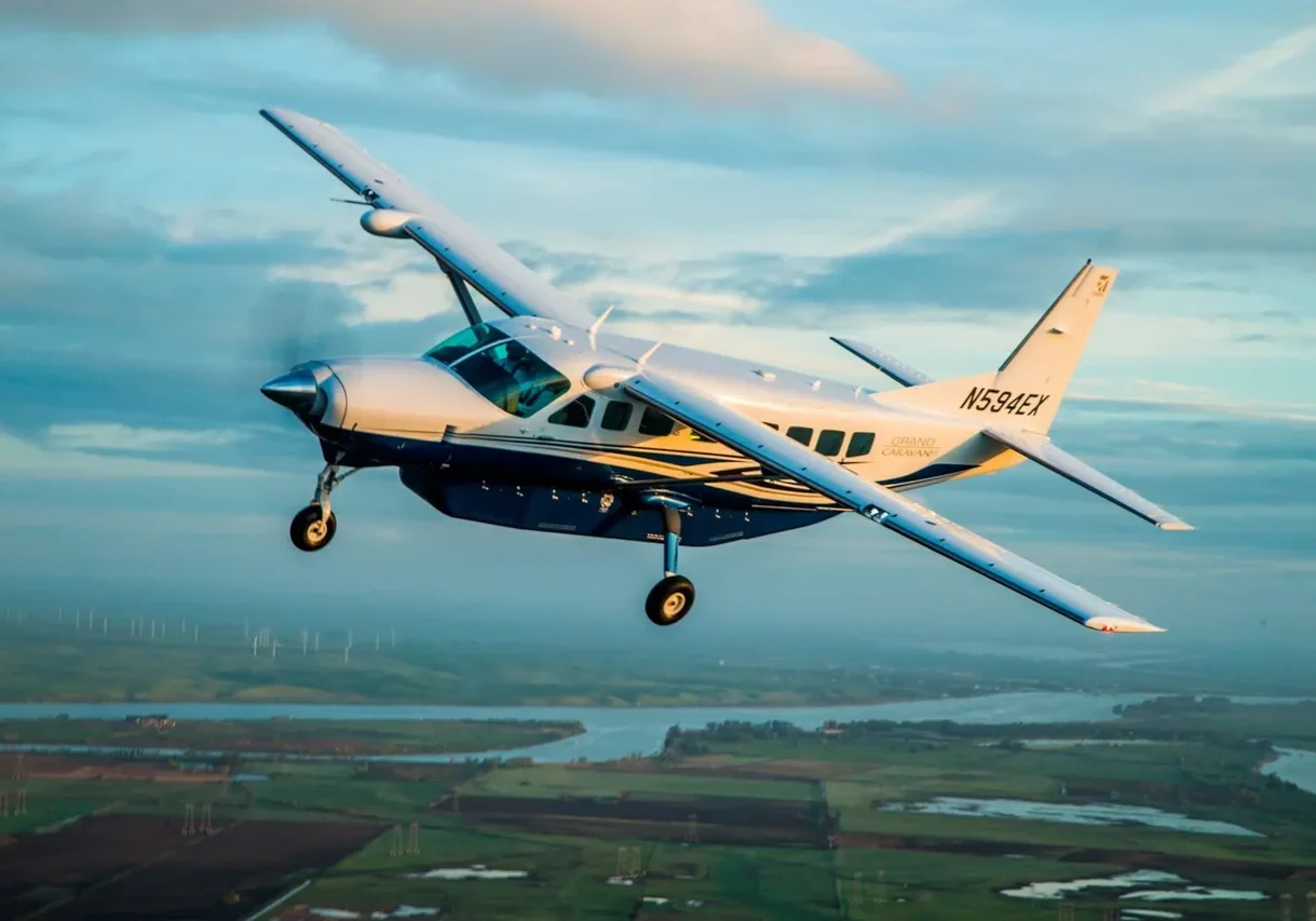 A small plane flying over the top of a field.